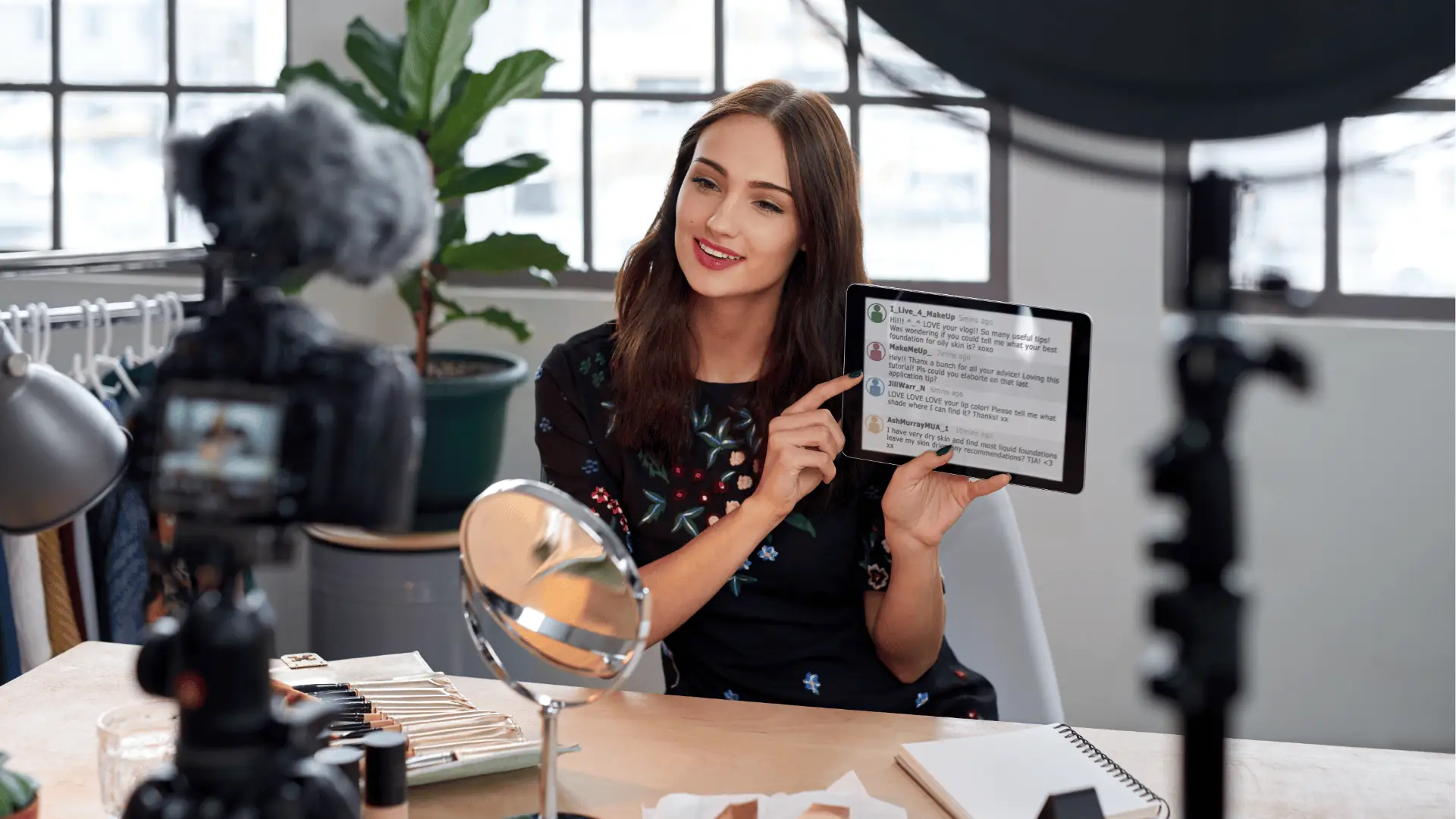 Woman vlogger holding tablet and demonstrating makeup in a home studio for scheduling