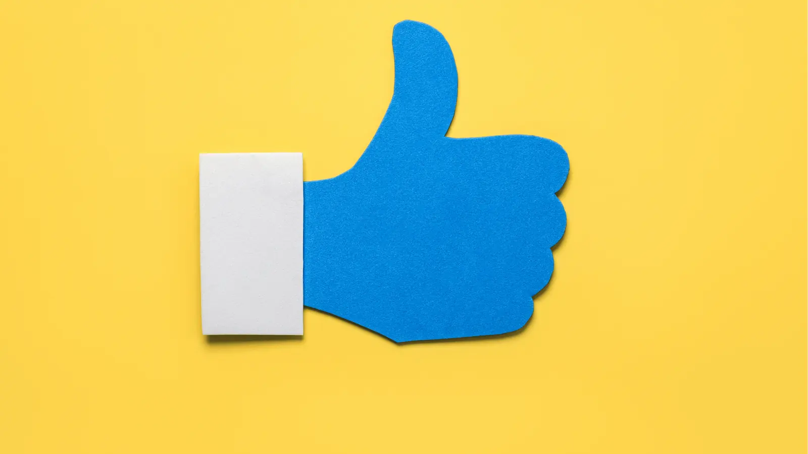 Blue thumbs-up cutout on yellow background with white cuff