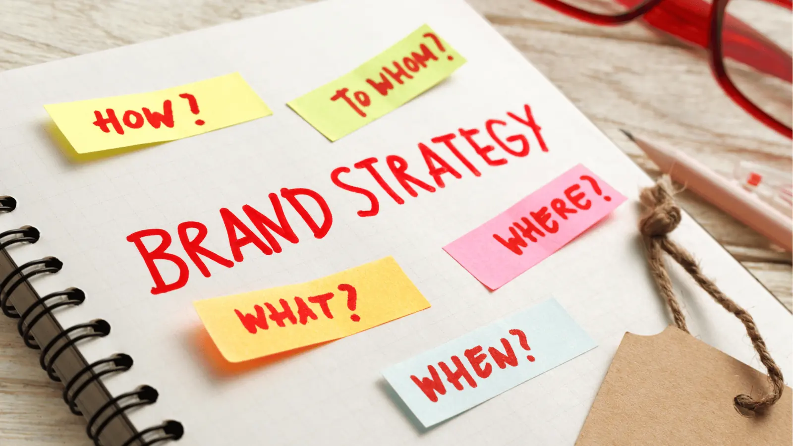 Notebook page with 'Brand Strategy' headline and colorful sticky notes
