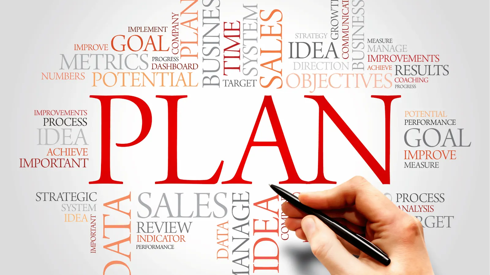 Hand holding a pen near a word cloud dominated by the red word PLAN for scheduling