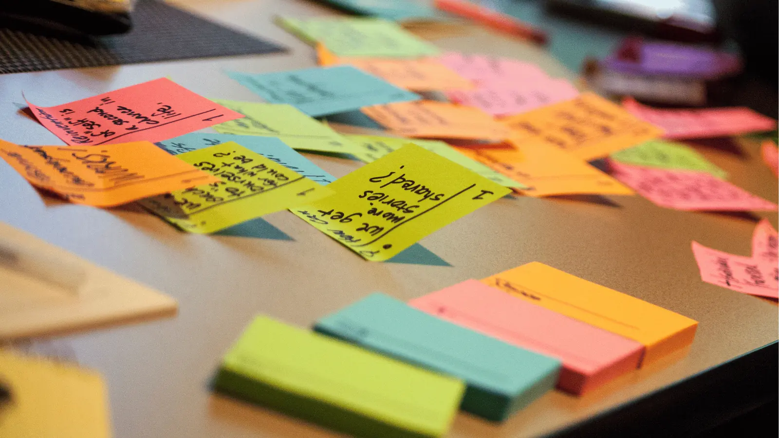 Colorful sticky notes with handwritten ideas scattered on a desk