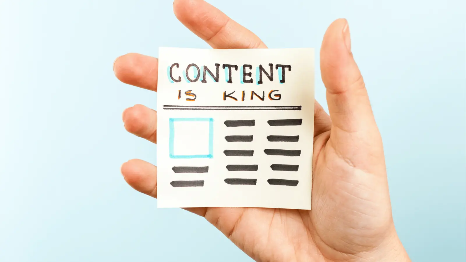 Hand holding sticky note reading 'Content is King' with drawn layout for approval workflow