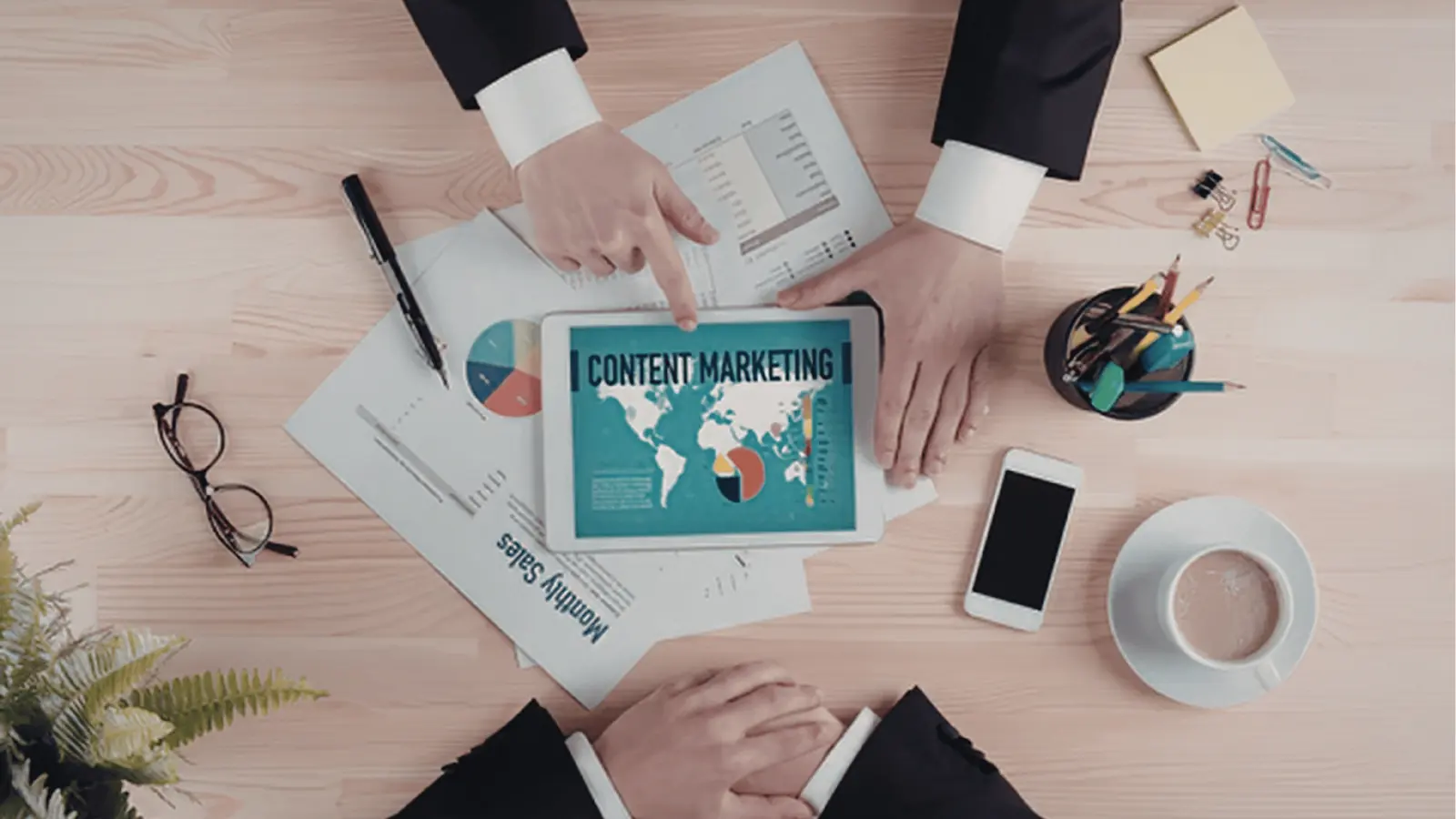 Overhead view of two people reviewing content marketing charts on tablet for publishing