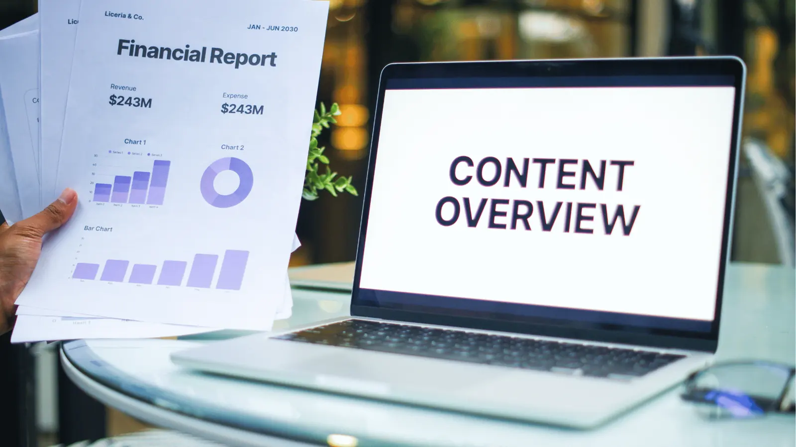 Laptop screen reading 'Content Overview' next to printed financial report with charts