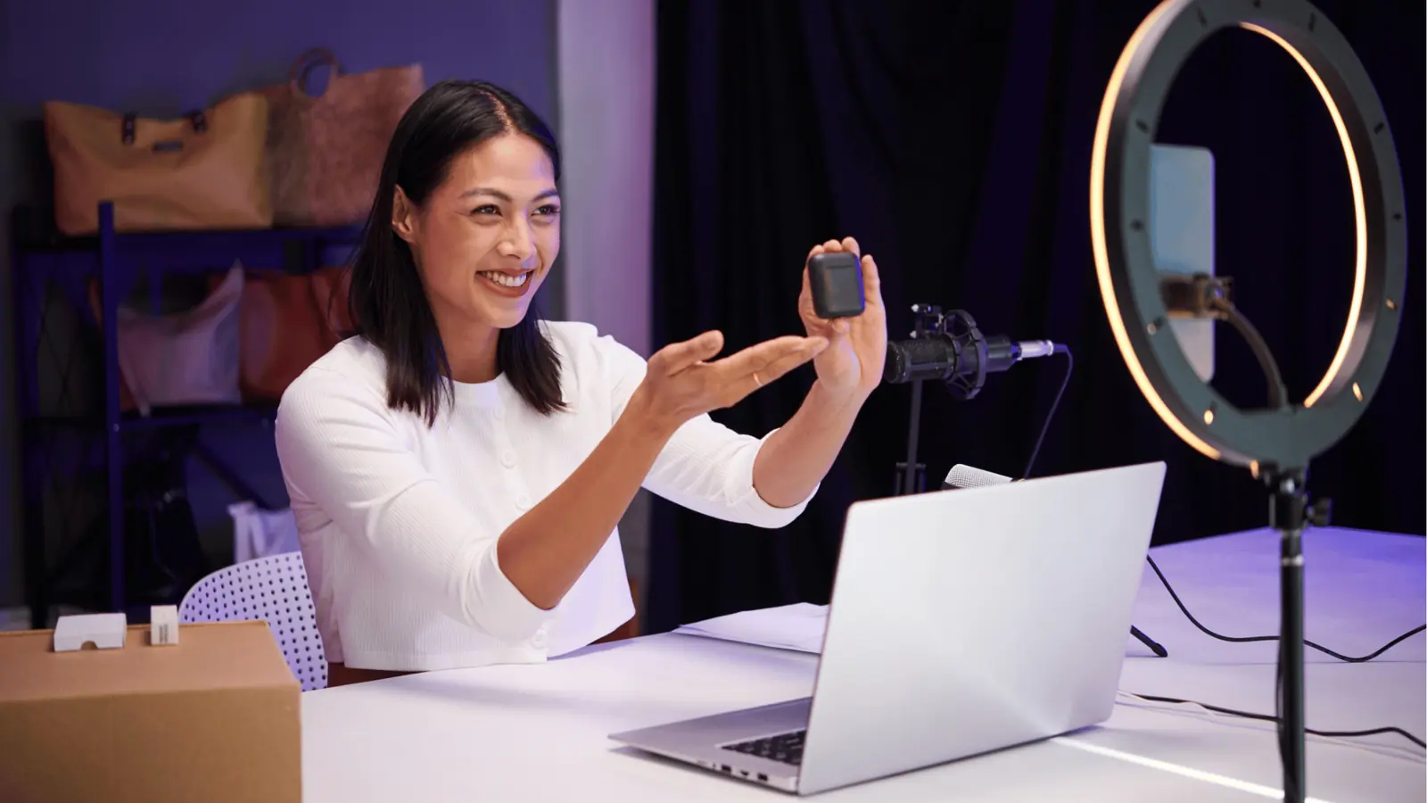 Woman demonstrating a small electronic product on camera with ring light for scheduling