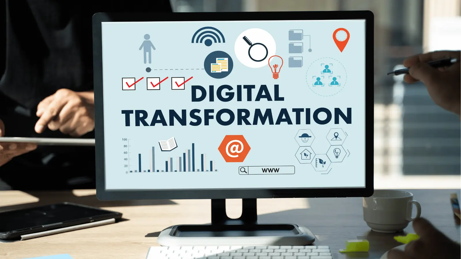 Computer monitor on desk showing 'Digital Transformation' slide with icons