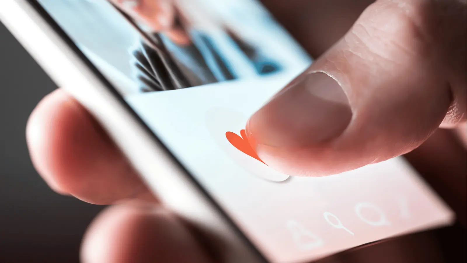 Close-up of a finger tapping a heart like button on smartphone screen
