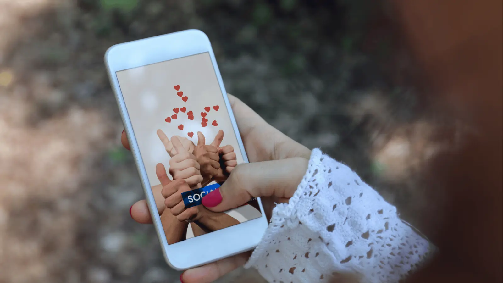 Hand holding smartphone showing thumbs-up graphics and floating red hearts