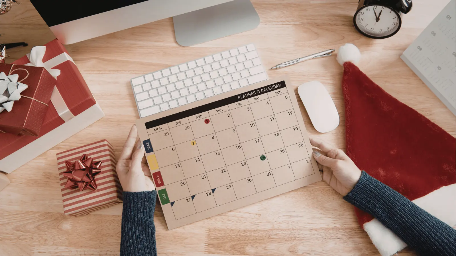 Desk calendar and planner open on a table during holiday campaign planning