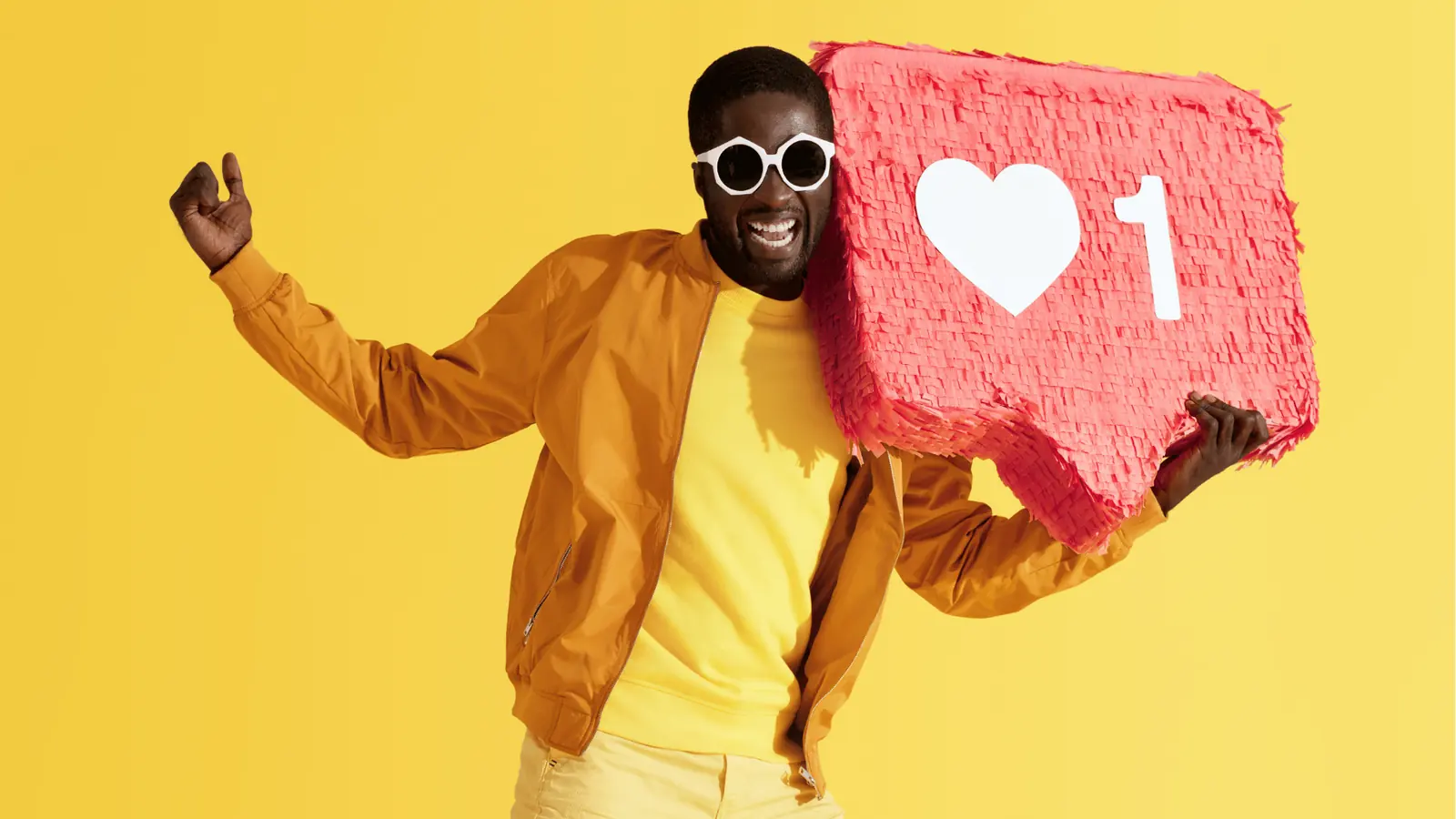 Smiling man wearing sunglasses holding a red like notification pinata for approval workflow