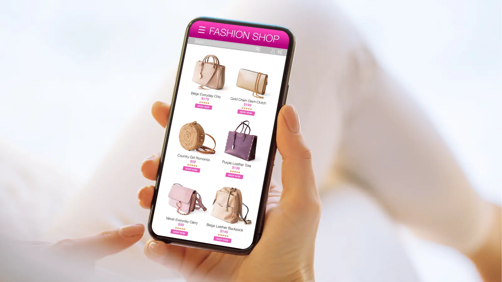Hands holding smartphone showing an online fashion shop listing handbags