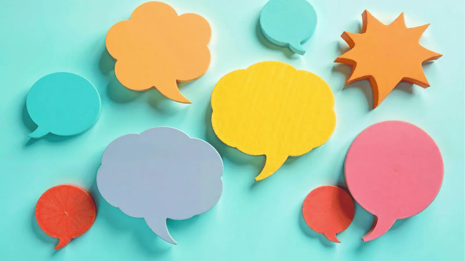 Colorful speech bubble cutouts arranged on a light teal background