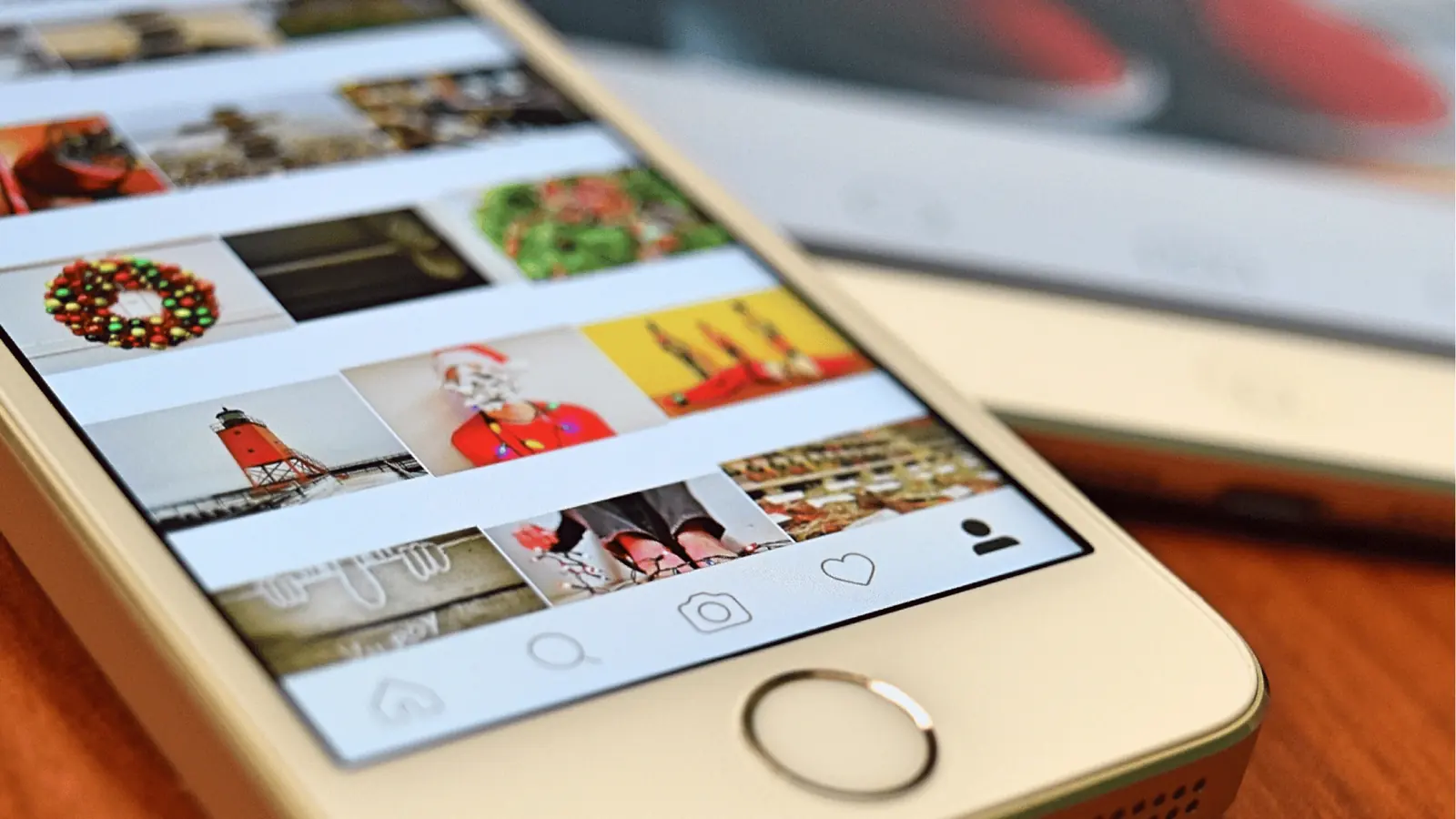 Close-up of smartphone showing a social media photo grid and navigation icons for brand management