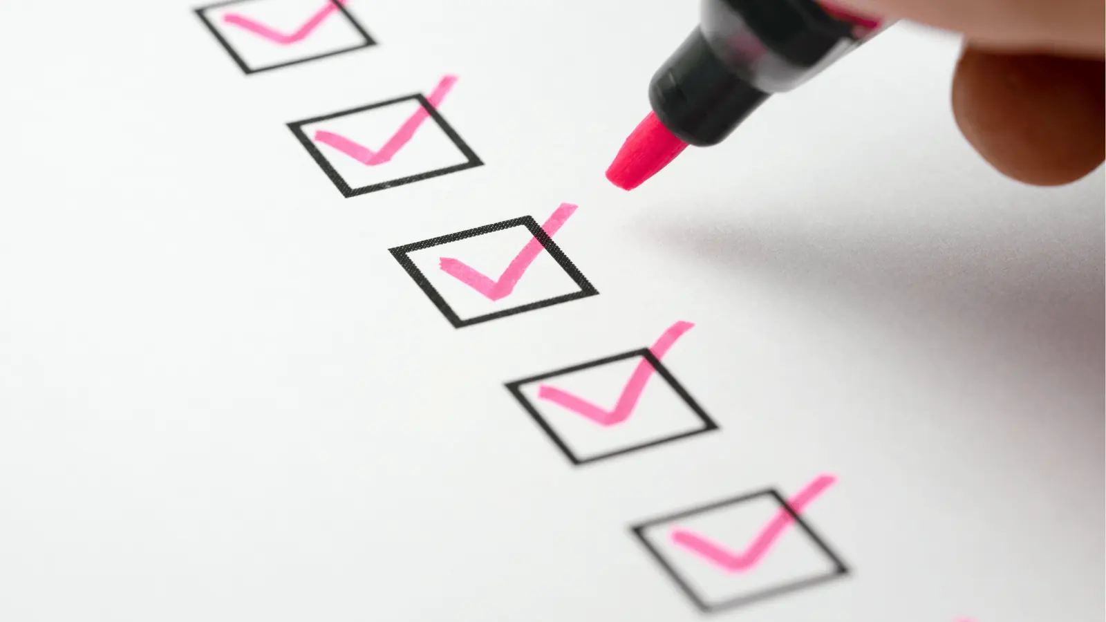 Checklist with pink checkmarks representing a free social media tool feature comparison