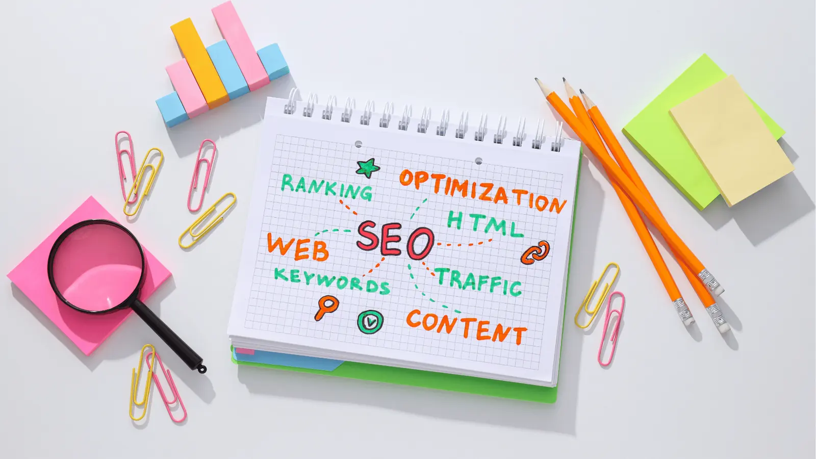 Overhead view of notebook with colorful SEO doodles and stationery