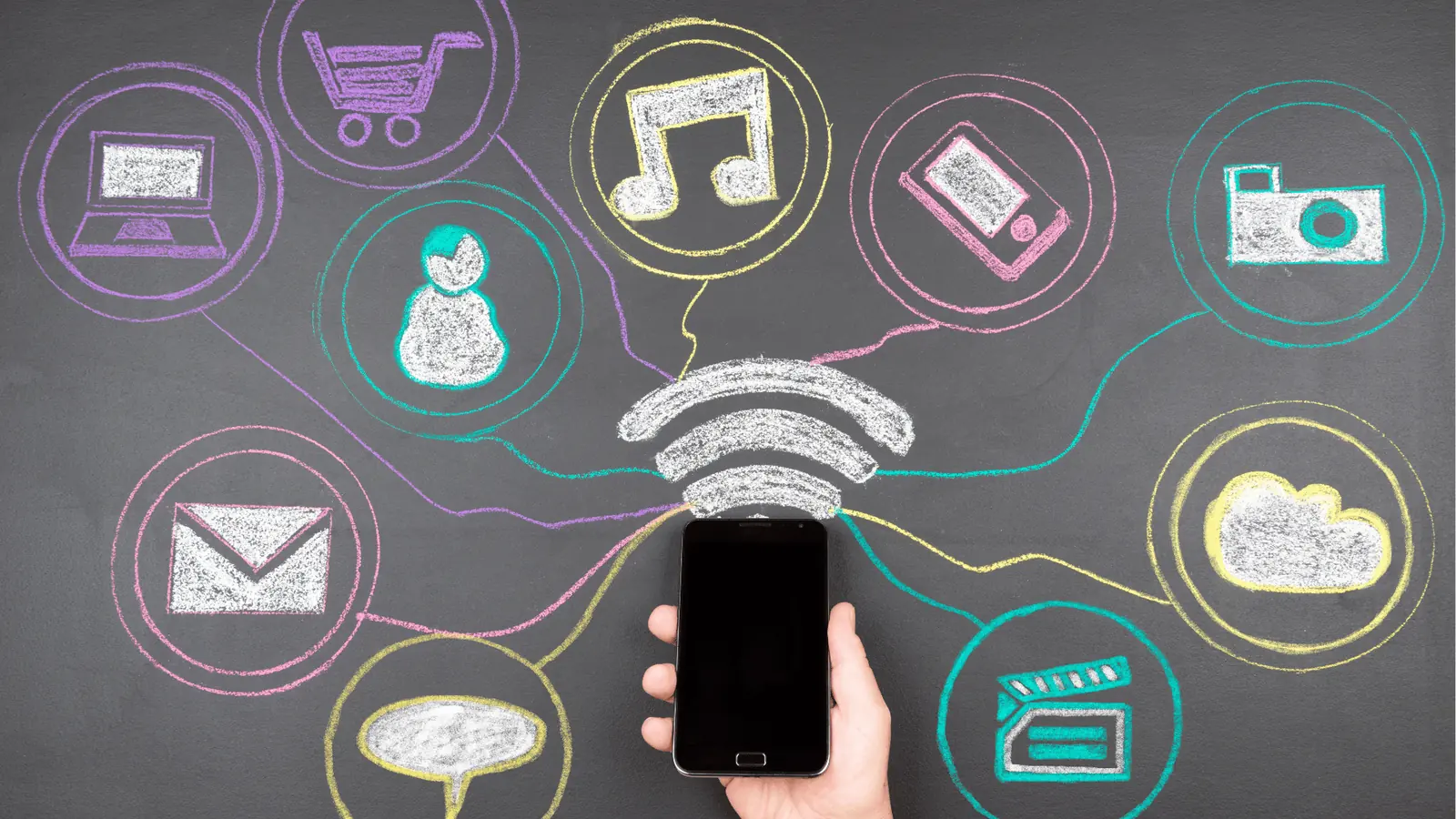 Hand holding smartphone below chalk-drawn app and wifi icons on blackboard