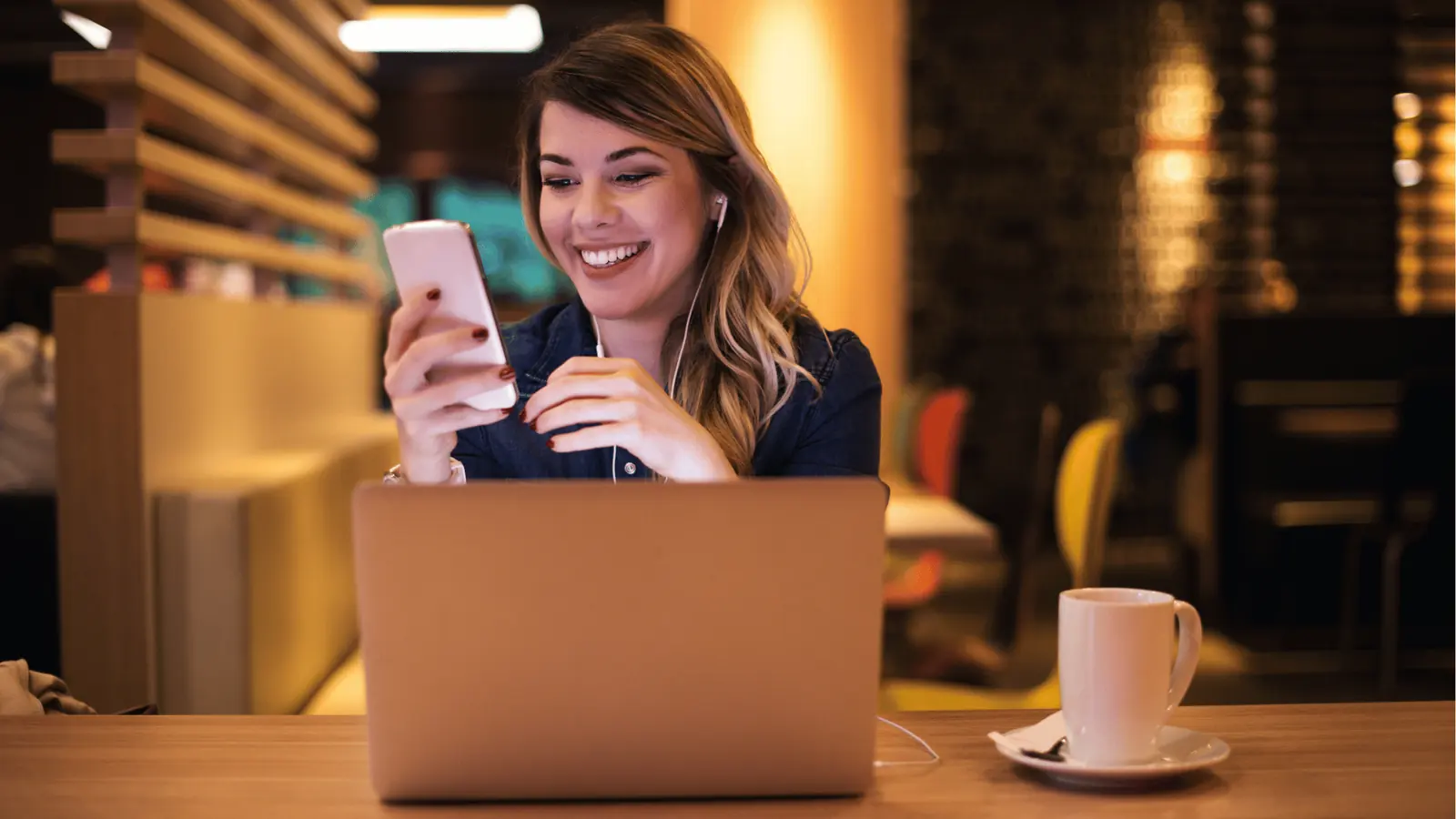 Smiling creator working on phone and laptop