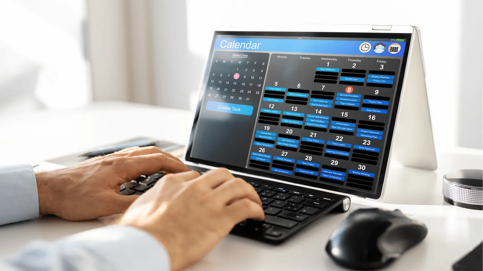 Person typing on keyboard next to tablet showing a monthly calendar app for ROI reporting