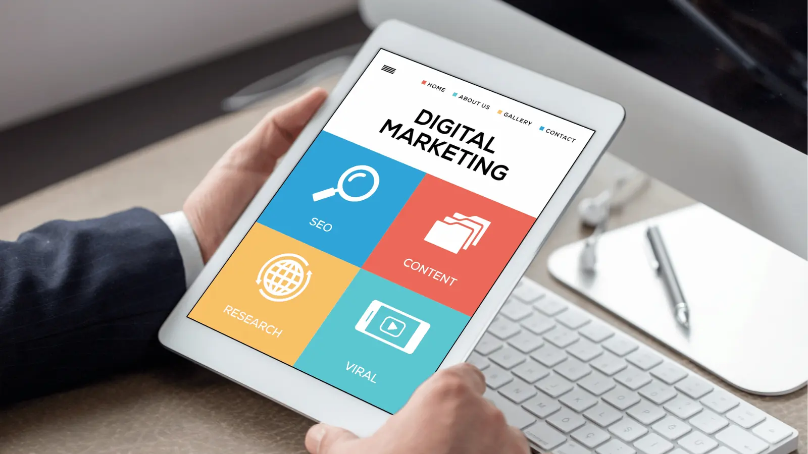 Person holding tablet displaying colorful digital marketing tiles and icons