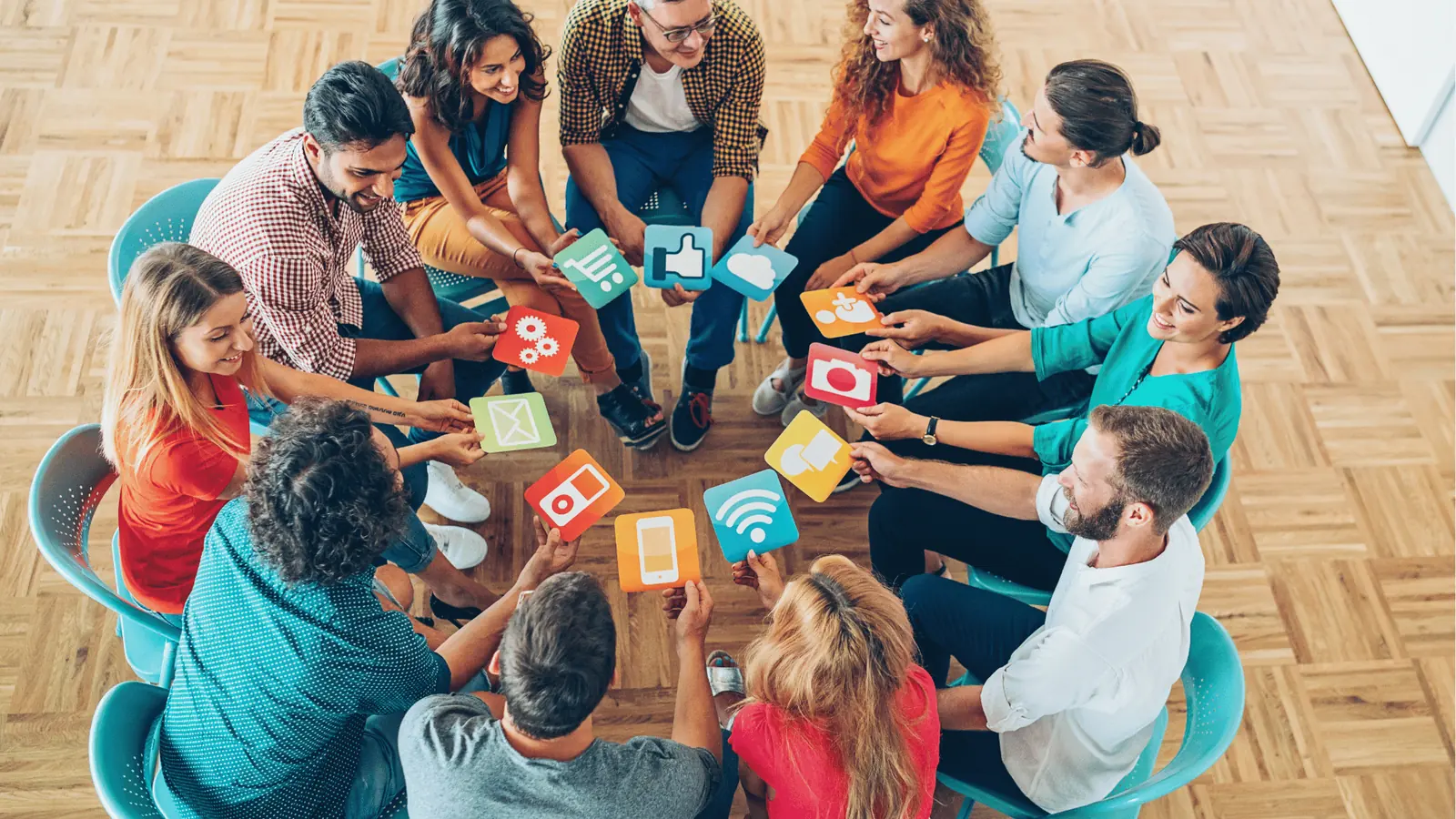 Group seated in circle holding colorful social media and app icon cards