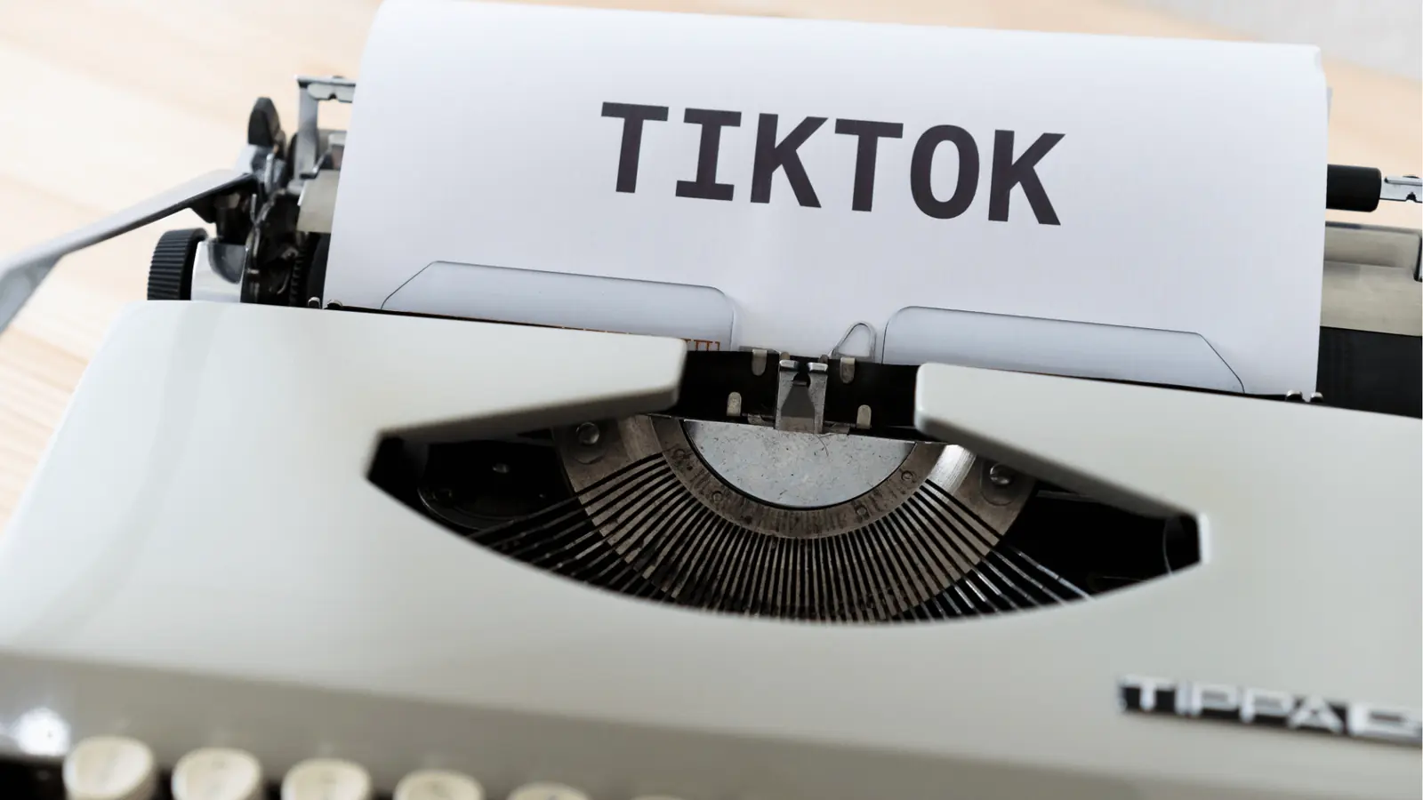 Close-up of a vintage typewriter with paper reading TIKTOK inserted