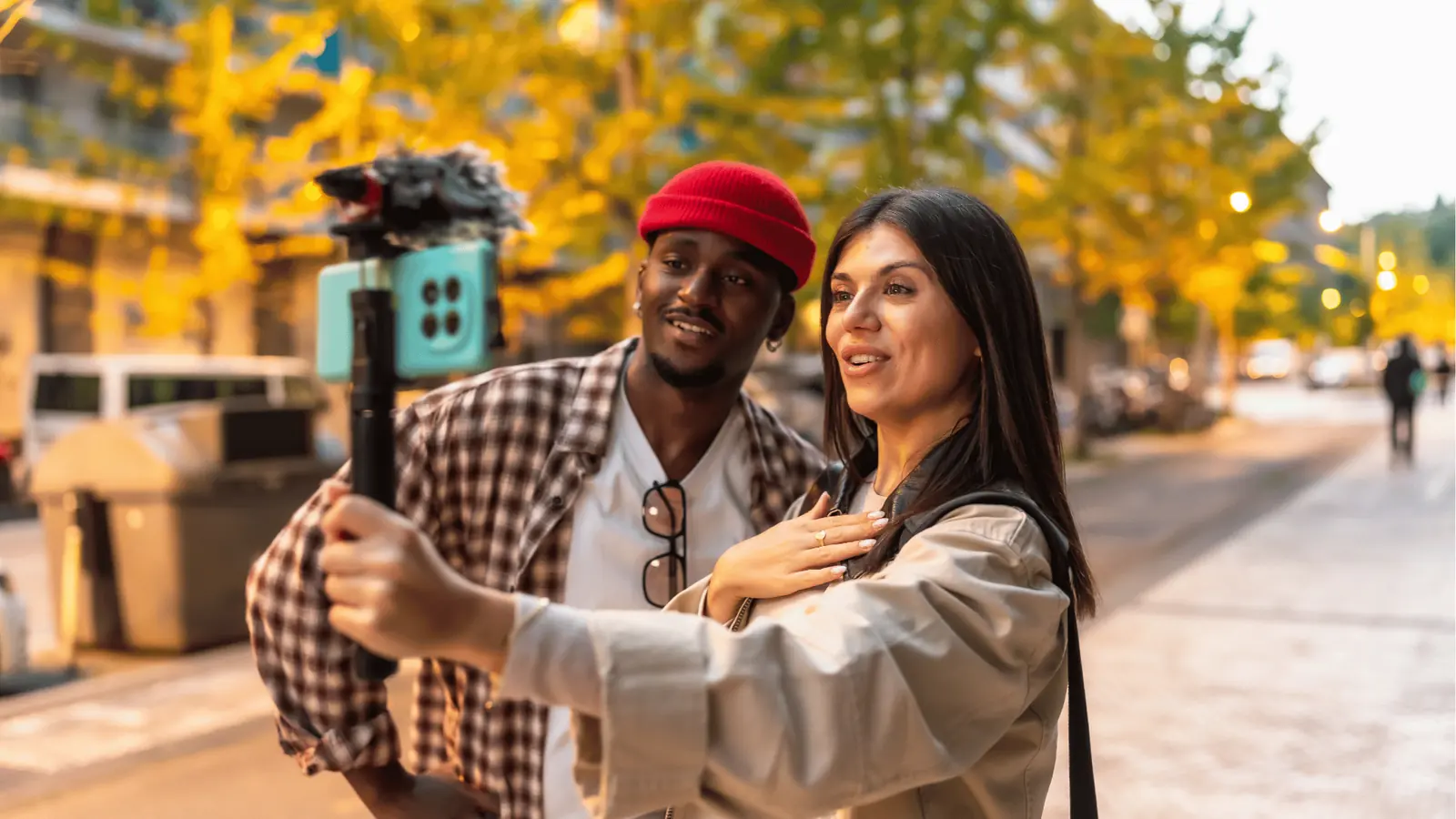 Two people recording a street vlog with smartphone and handheld mic