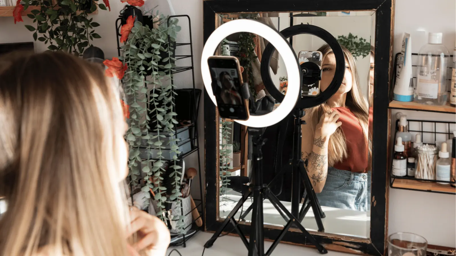 Woman recording herself in mirror with ring light and smartphone