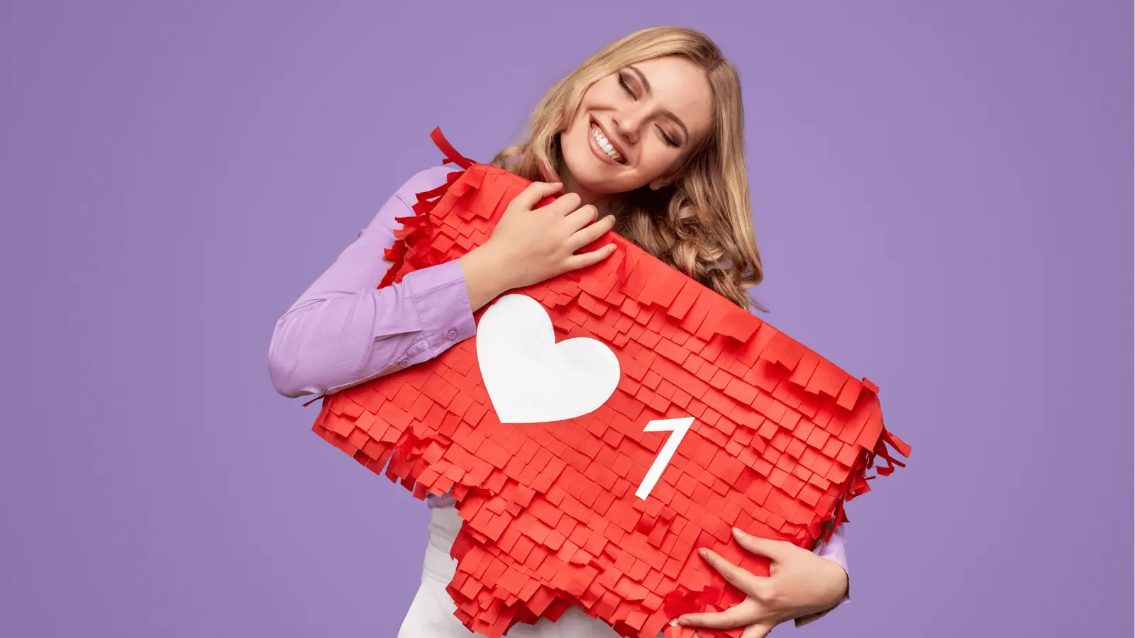 Smiling woman hugging a large red heart prop with white like icon for brand management