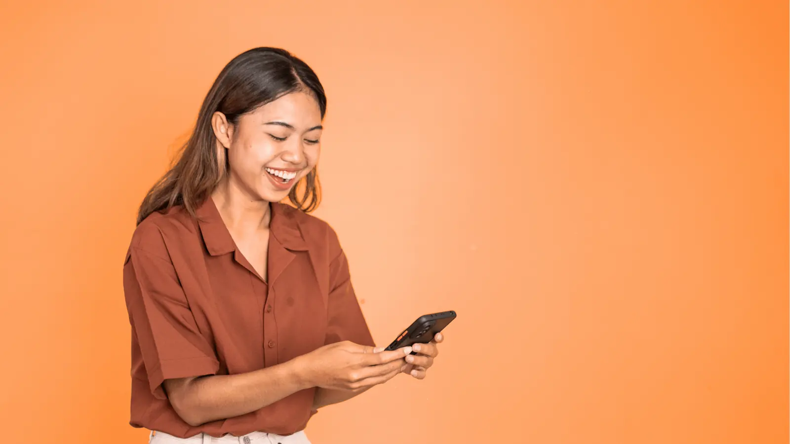 Woman smiling while looking at her phone